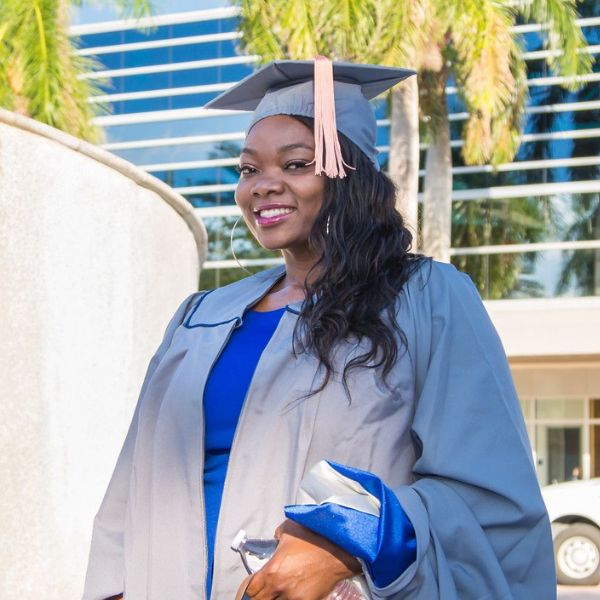 NSU graduate in cap and gown smiling