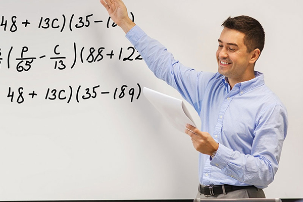 Mathematics teacher writing equation on whiteboard