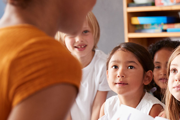 over the shoulder view of a teacher speaking to young children